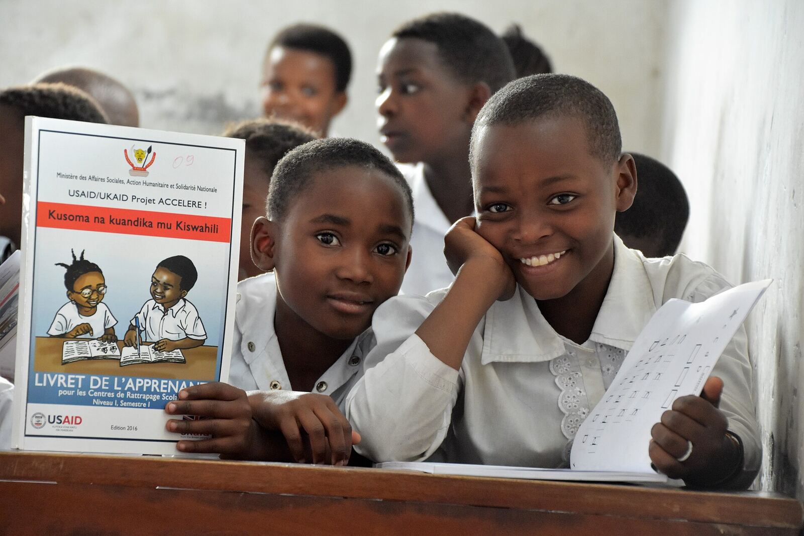 DRC Students | RaspGold English Students in a classroom use learning materials funded by USAID/UKAID, demonstrating international educational support.