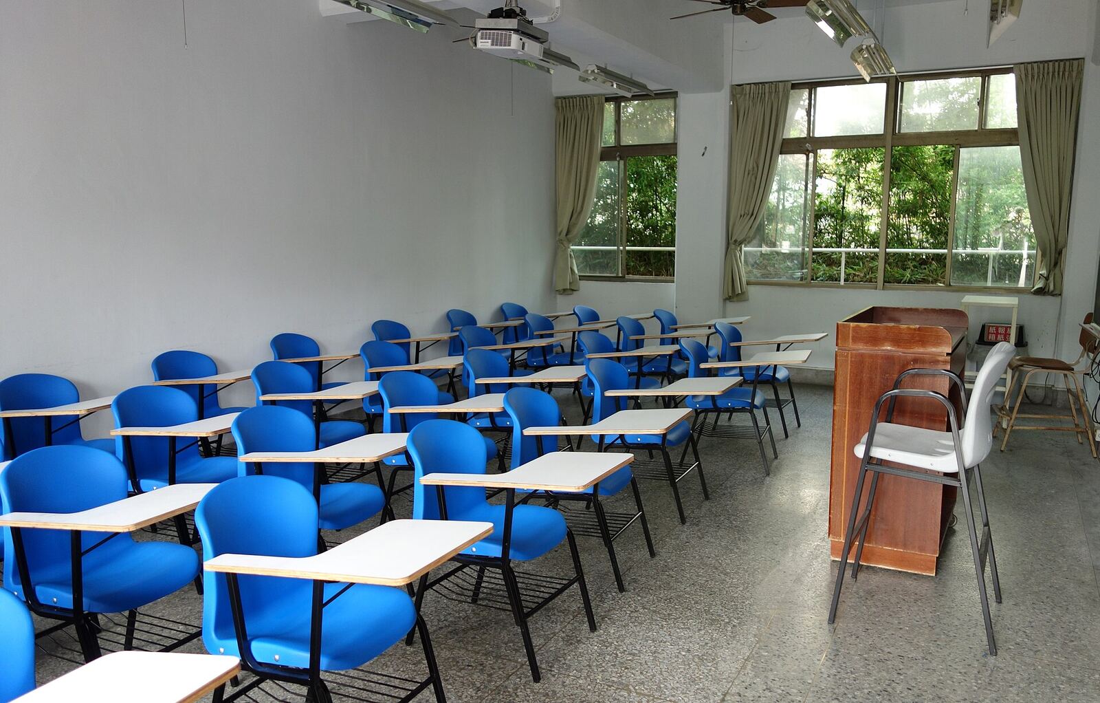 University Classroom | RaspGold English A classroom with student desks and chairs provides a setting for online english lessons.